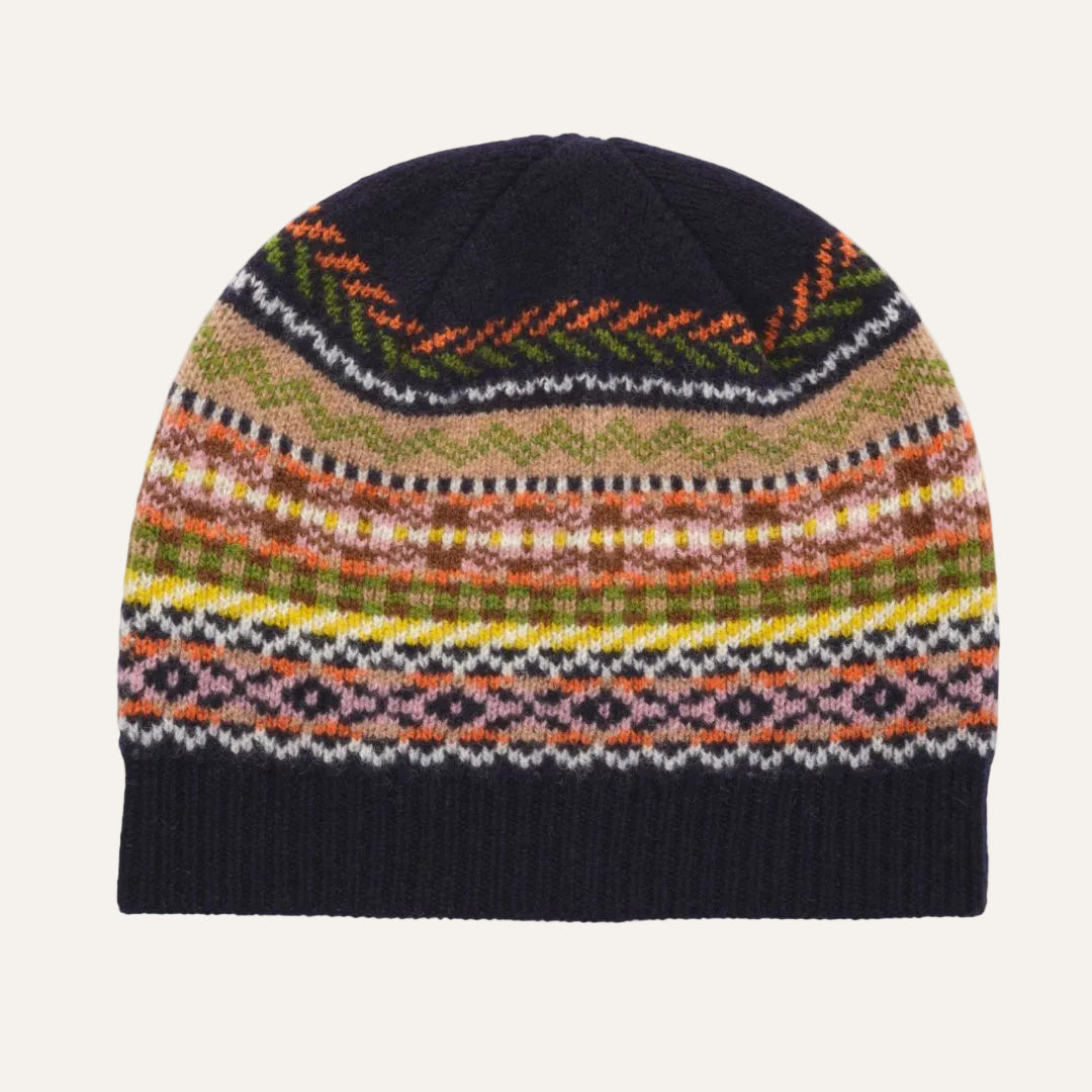 A multicolor knit beanie hat with a dark navy blue ribbed cuff and top panel, featuring intricate geometric and zigzag patterns in orange, green, beige, yellow, pink, and white.
