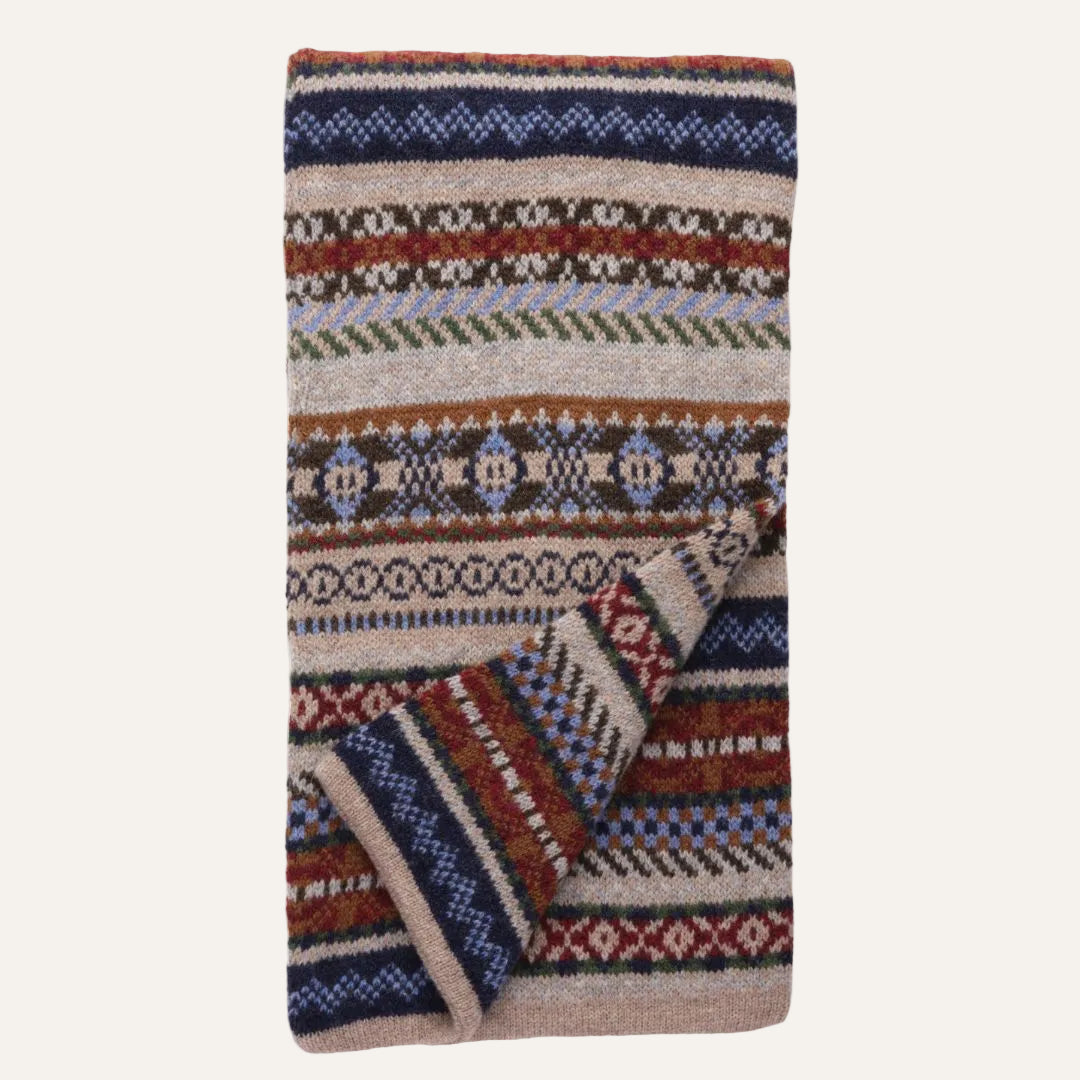 Knit scarf featuring a multi-colored Fair Isle pattern with stripes of navy blue, rust red, beige, brown, and light blue on a white background.
