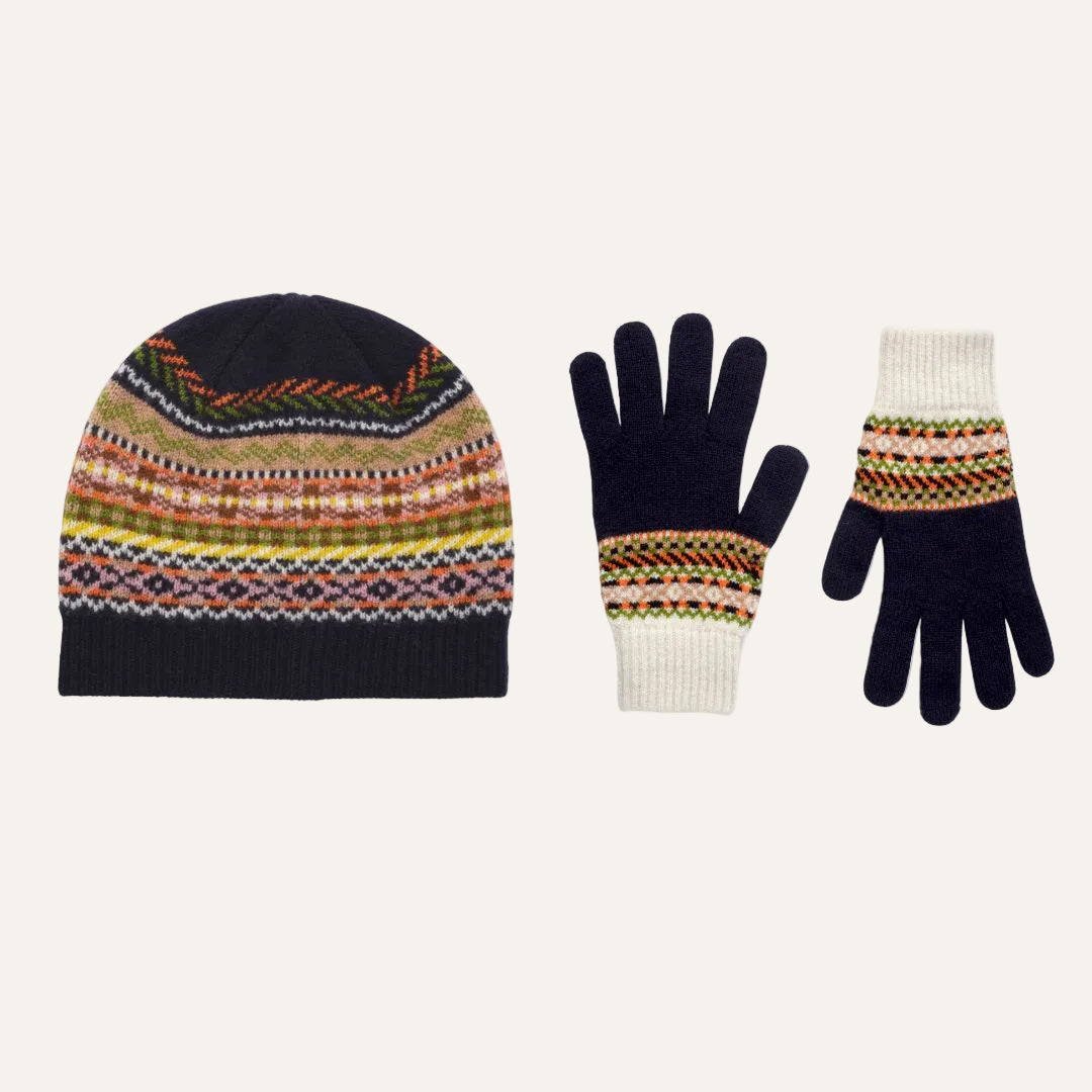 A knit winter set featuring a beanie and matching gloves. The beanie and the right glove have a dark navy blue base with a multicolor Fair Isle pattern in orange, yellow, green, and white.