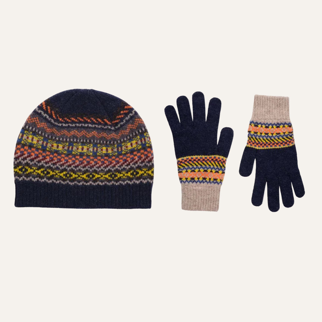 A knit beanie hat and matching gloves set on a plain white background. The beanie and glove cuffs feature a multicolor Fair Isle pattern with navy, orange, yellow, red, and beige, while the main body of the hat and glove fingers are solid navy.