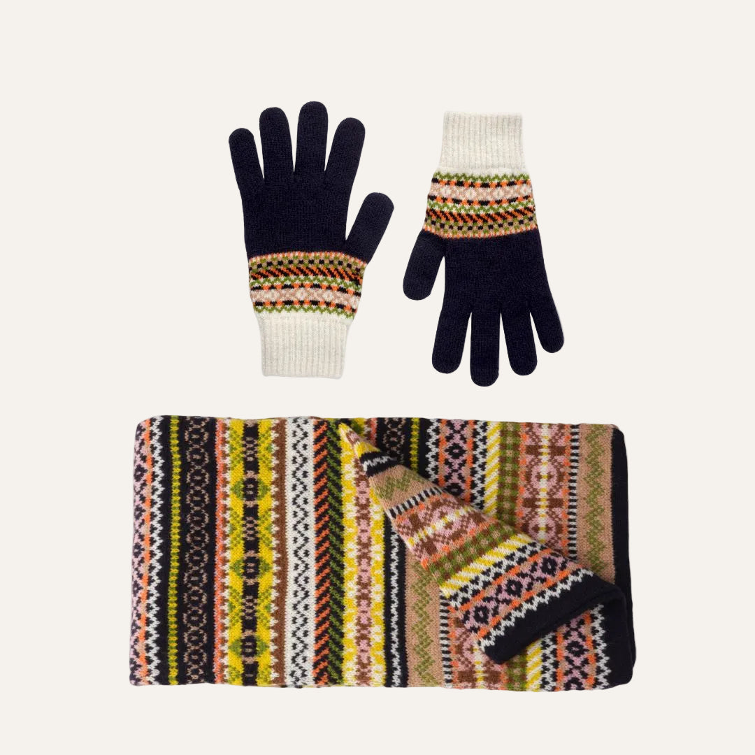 Lambswool knit accessory set on a white background, including a matching scarf and gloves. The gloves are dark navy with cream ribbed cuffs and a multicolor geometric pattern band.