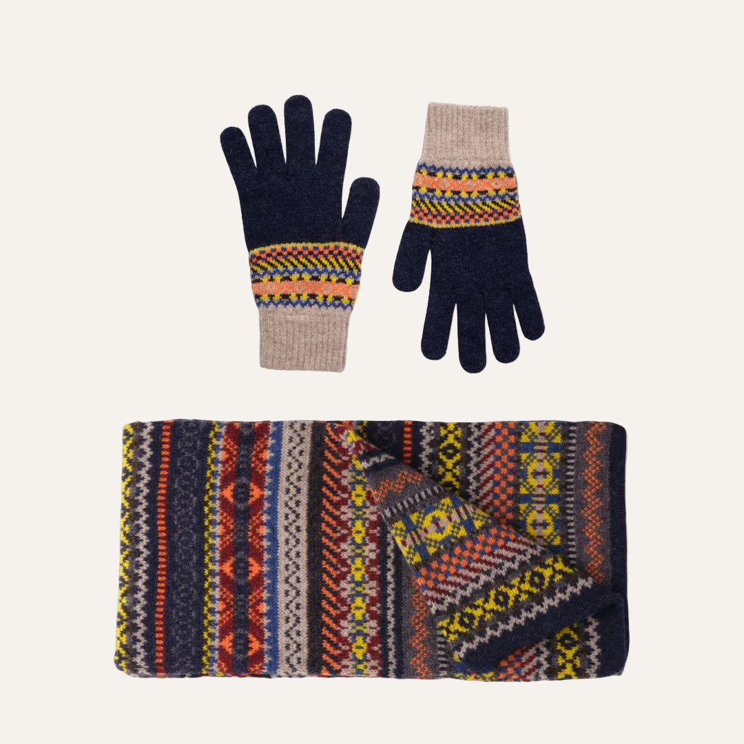 Lambswool knit accessory set featuring a matching scarf and gloves. The gloves have dark navy blue fingers and backs with a beige cuff and a colorful geometric Fair Isle pattern around the wrist.