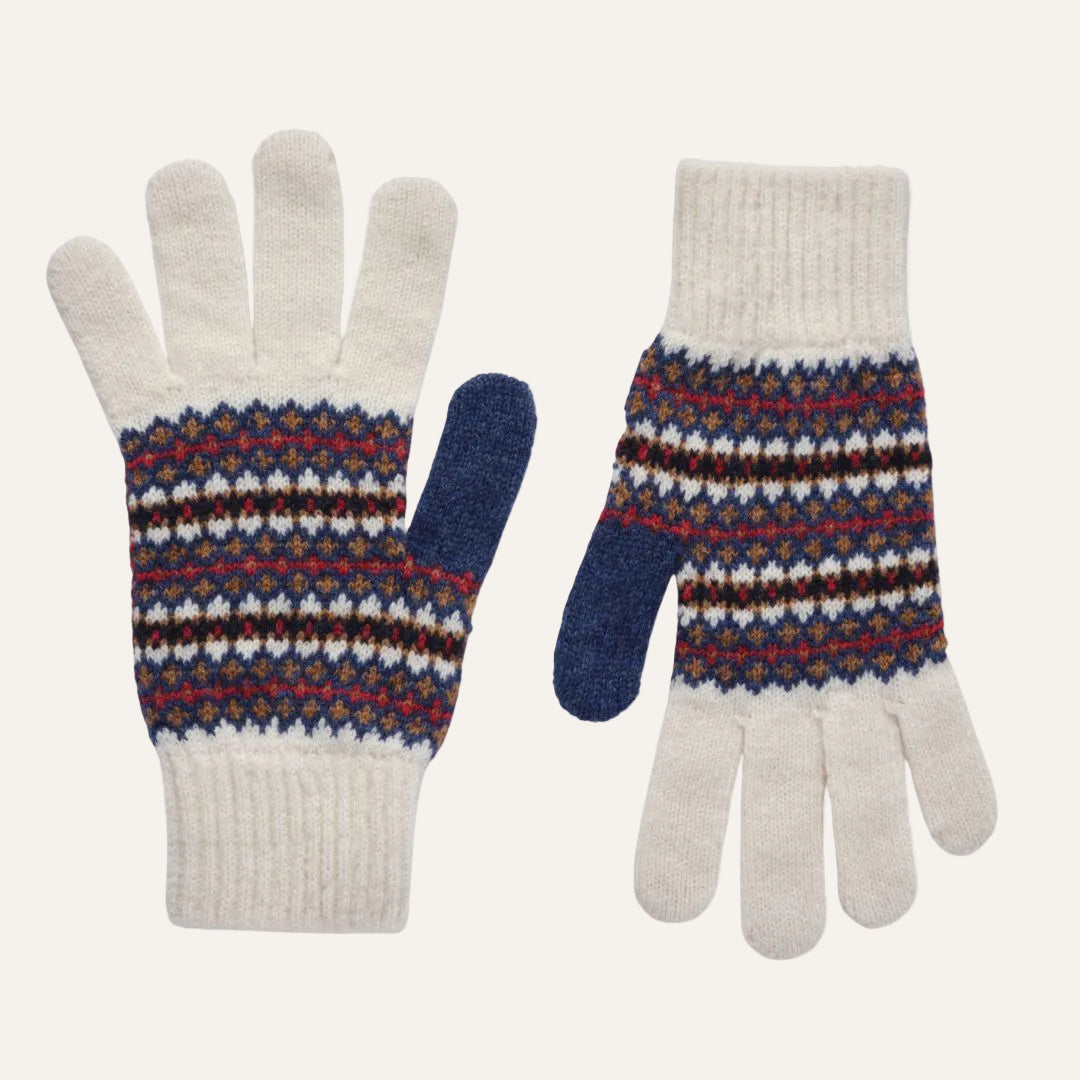 A pair of knit winter gloves with a cream-colored finger and cuff, featuring a multicolor Fair Isle patterned wrist section with blue, red, brown, and white stripes, and solid blue thumb sections.
